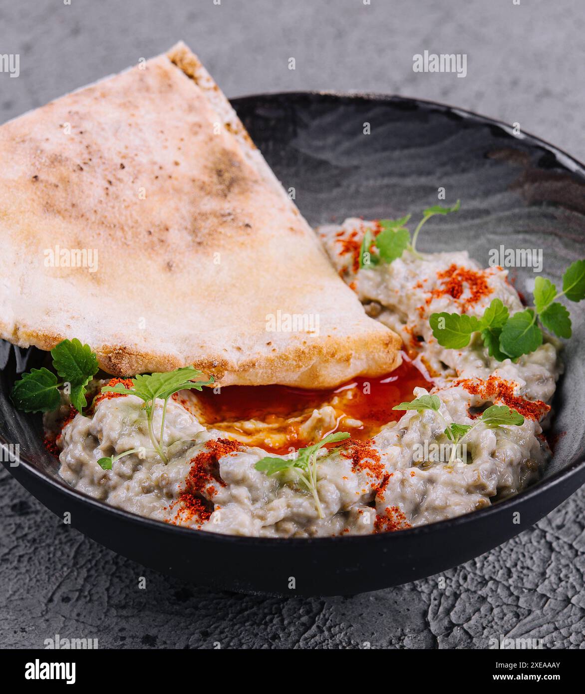 Caviale di melanzane con lavash su una ciotola nera Foto Stock