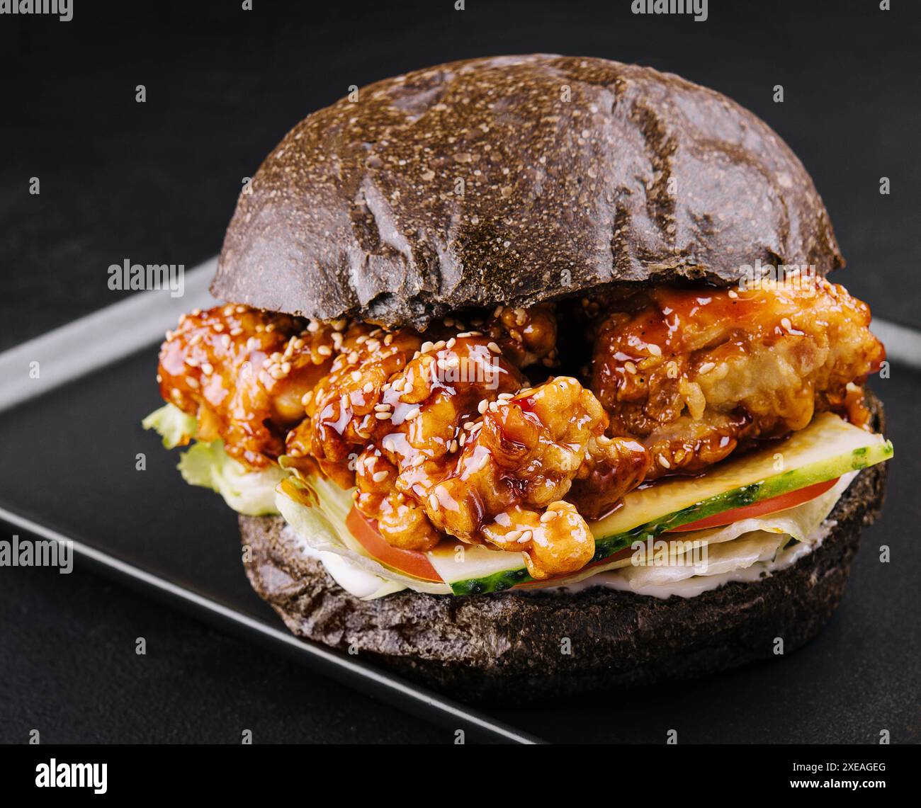 Hamburger con strisce di pollo fritte su vassoio nero Foto Stock