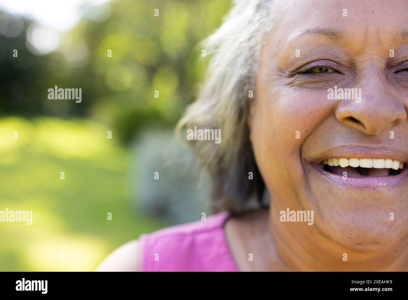 Donna anziana sorridente che si diverte all'aperto, primo piano del viso con espressione gioiosa, copia spazio Foto Stock Donna anziana sorridente che si diverte all'aperto, primo piano del viso con espressione gioiosa, copia spazio Foto Stock