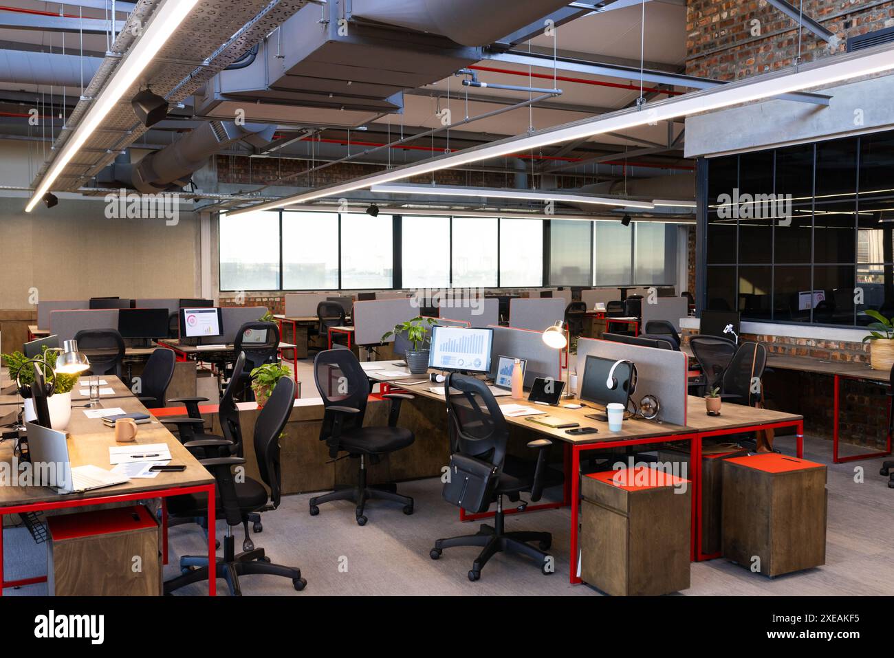 Moderno ufficio open space con scrivanie, computer e sedie, pronto per il lavoro Foto Stock