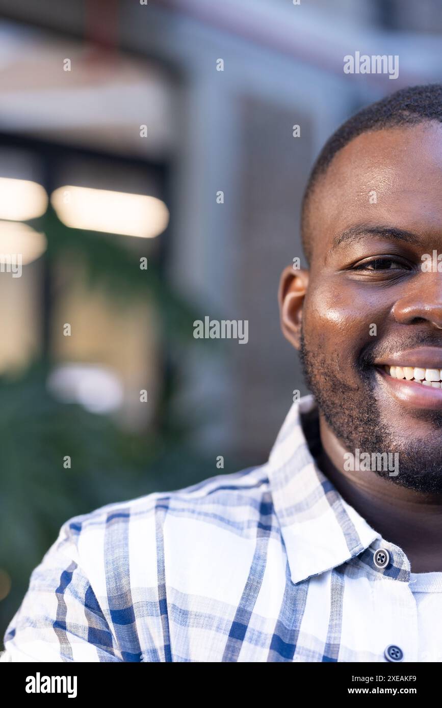 Uomo sorridente in un abbigliamento casual per affari all'aperto, godendosi la giornata di sole Foto Stock