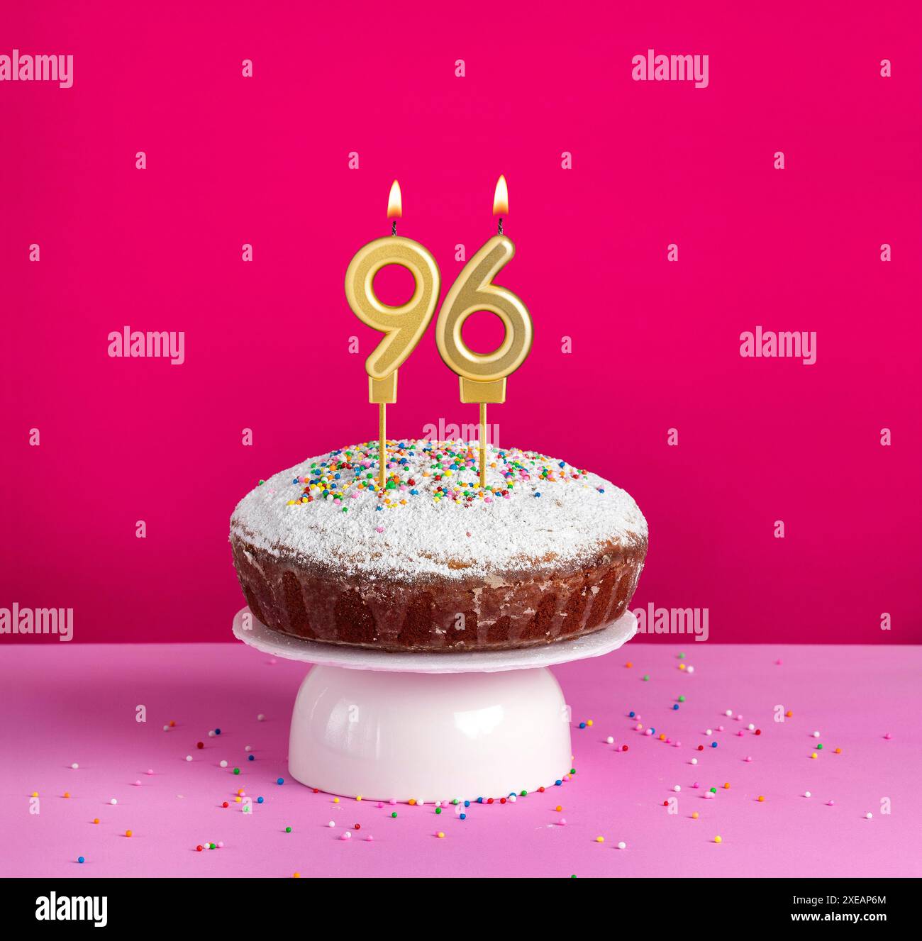 Candela di compleanno illuminata numero 96 - biglietto di compleanno su sfondo rosa Foto Stock