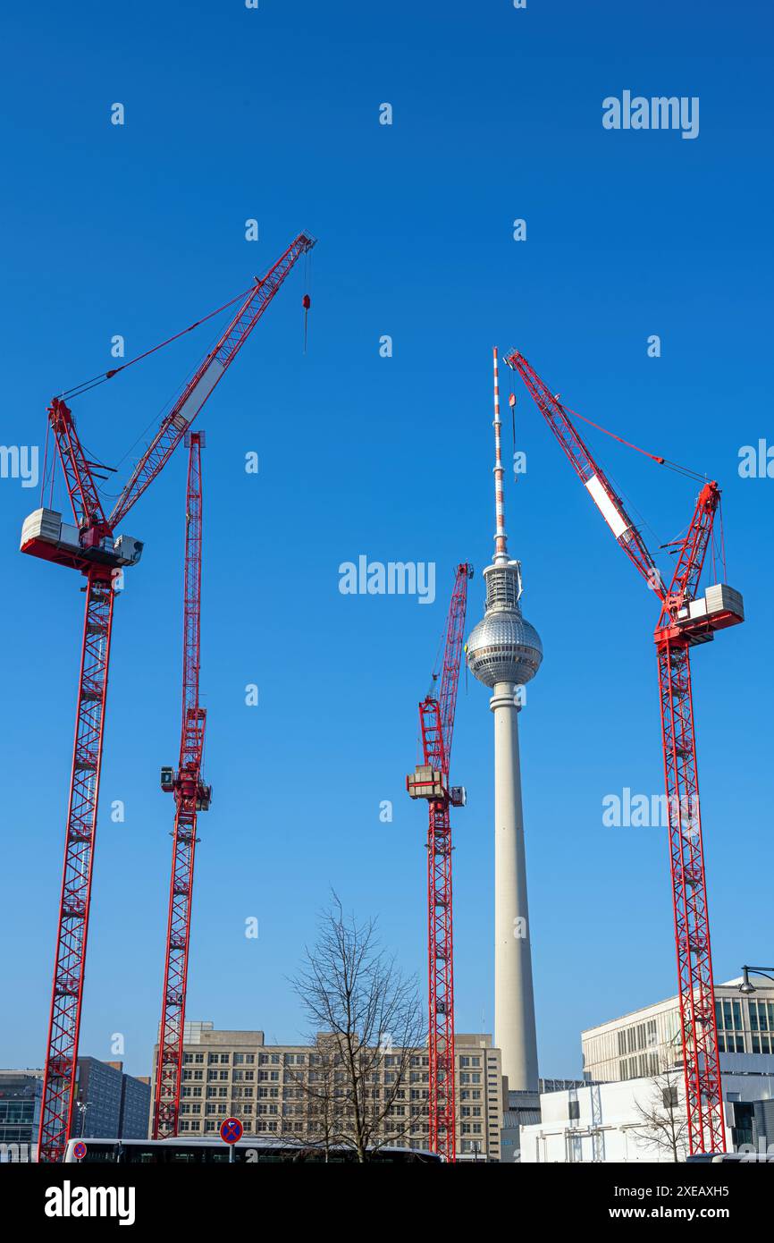 La famosa torre della televisione di Berlino con quattro gru a torre rosse Foto Stock