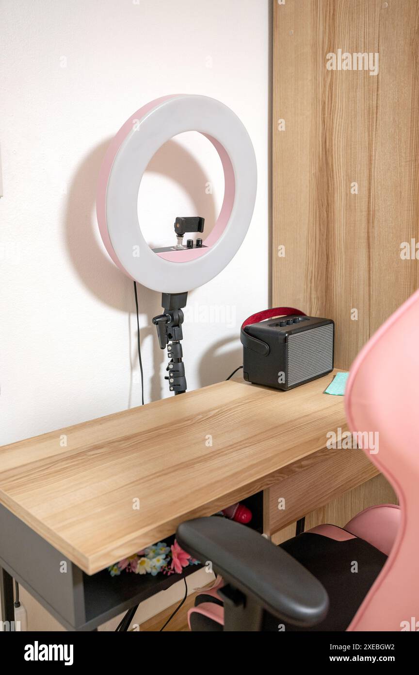 Luce LED selfie con tavolo in legno, sedia da gioco e altoparlante nella stanza Foto Stock