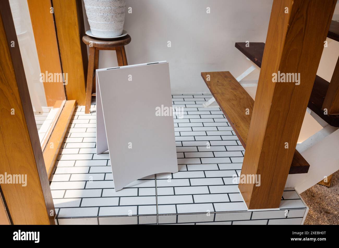 Modella un cartello bianco bianco in piedi sul pavimento in una casa di legno Foto Stock