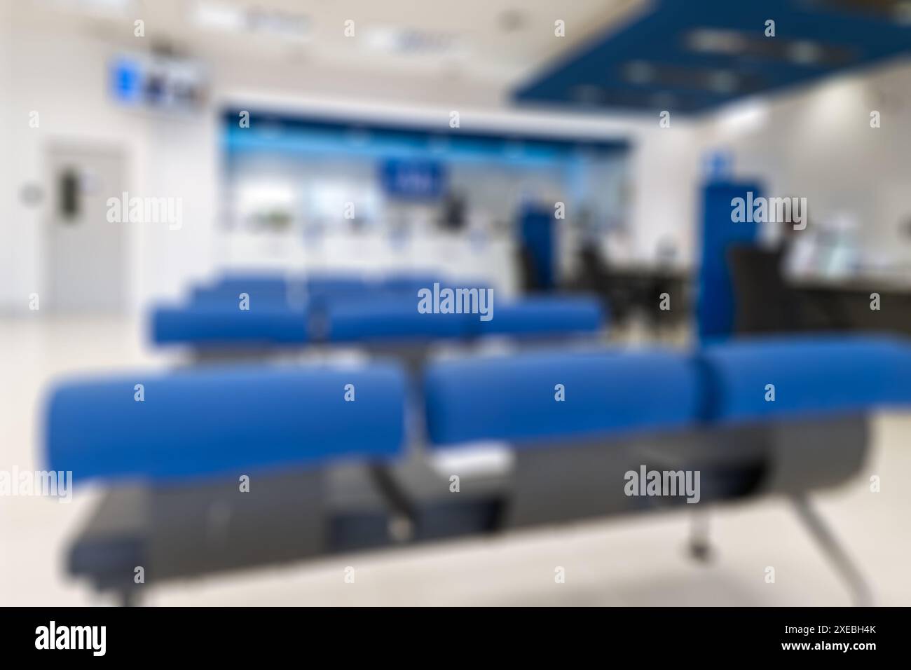 Scenario sfocato di una banca moderna con sedile blu e sfondo cassa Foto Stock