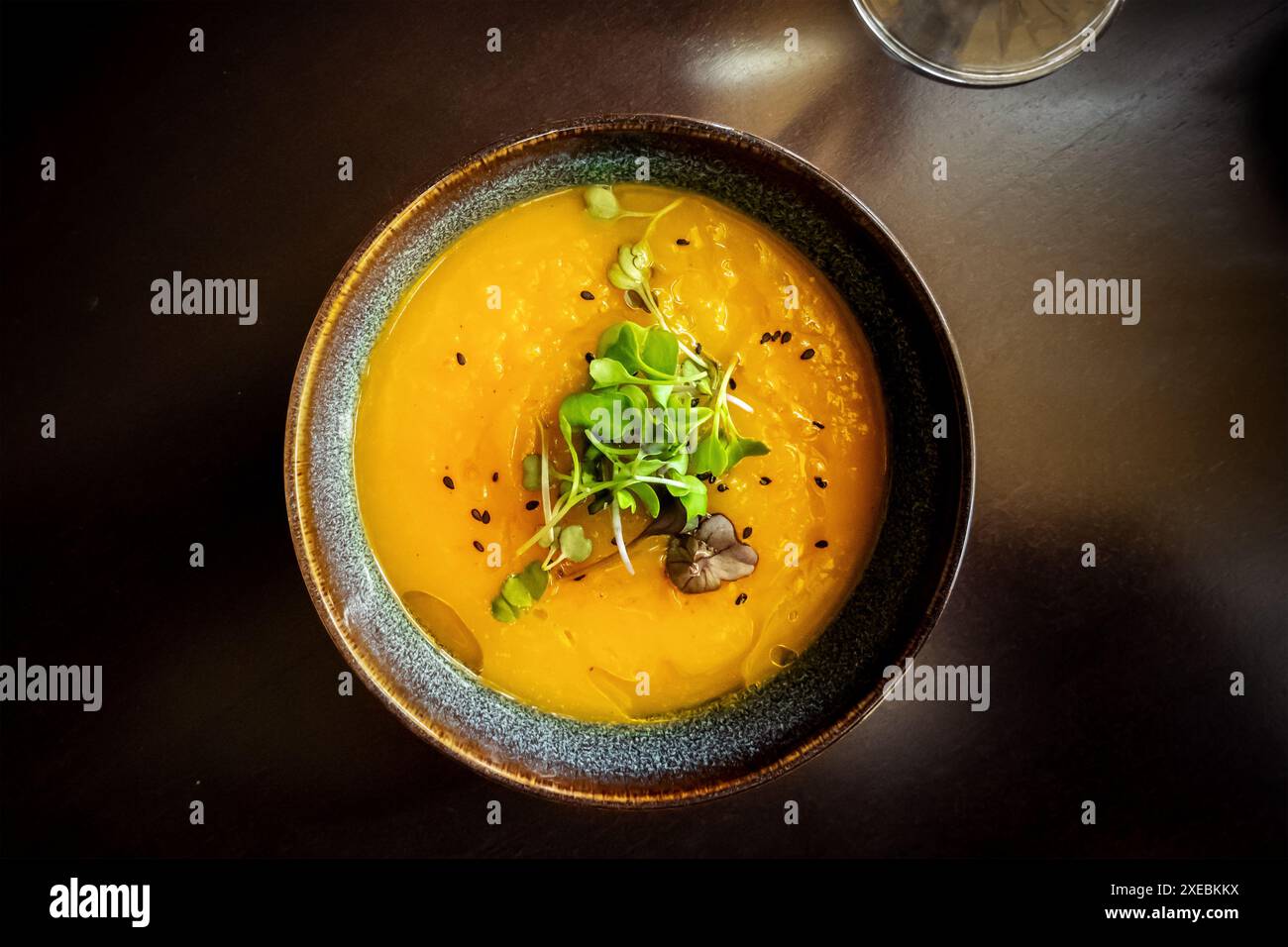 Microgreens su zuppa di zucca in un ristorante vegano, elegante piatto sano Foto Stock