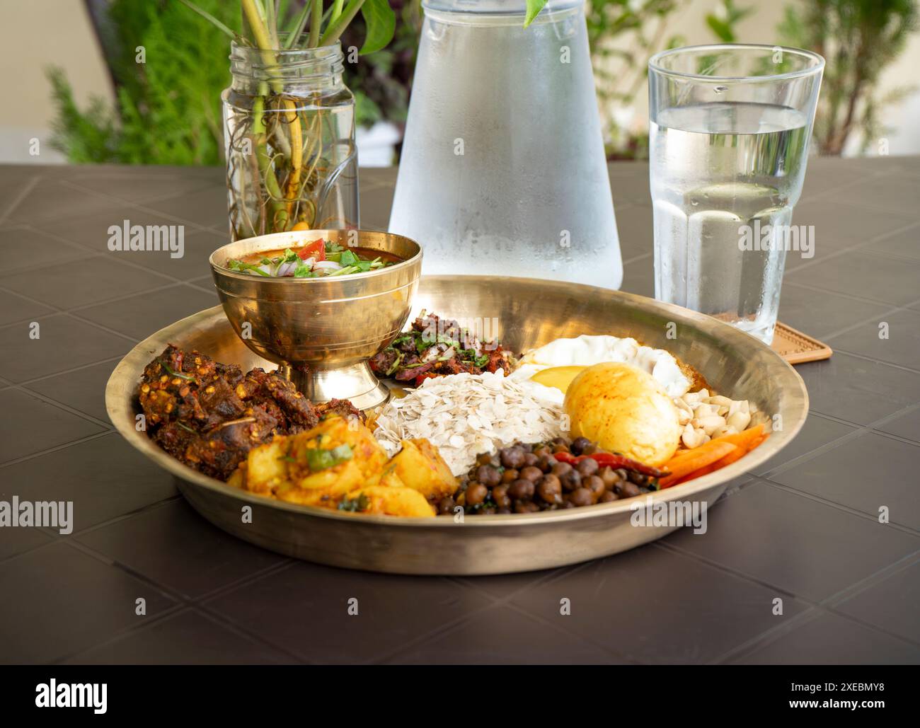 Newari Khaja Set tipico Thali nepalese con fiocchi di riso, Choyila, uova, ceci, Tama, zuppa di bambù, pranzo Aalu Sadheko Foto Stock