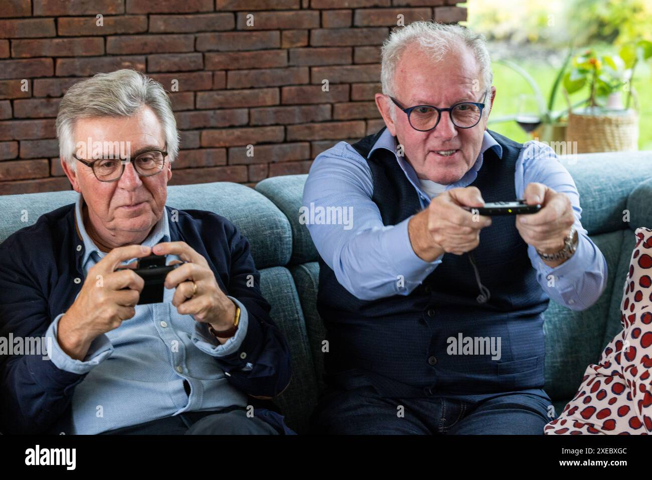 Uomini senior impegnati nel videogioco sul divano Foto Stock