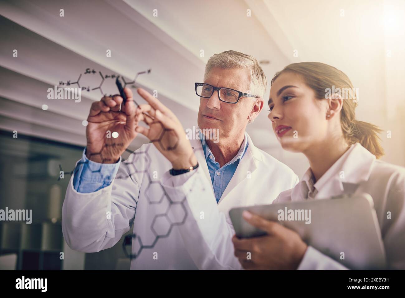 Scienziati, esperimenti e ricerche con collaborazione, scrittura o innovazione per appunti o discussioni in laboratorio. Uomo, donna e parete di vetro per Foto Stock