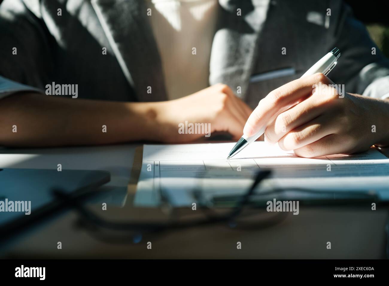 Una donna sta scrivendo con una penna su un pezzo di carta Foto Stock