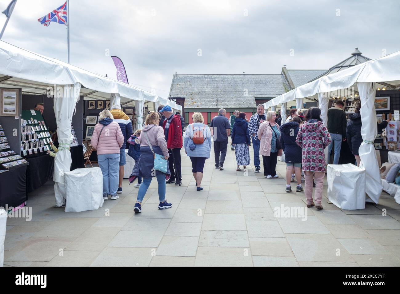 La gente del posto e i turisti si mescolano a una fiera di artigianato pop-up nel cuore di Whitby, nel North Yorkshire, durante una festività nel Regno Unito Foto Stock