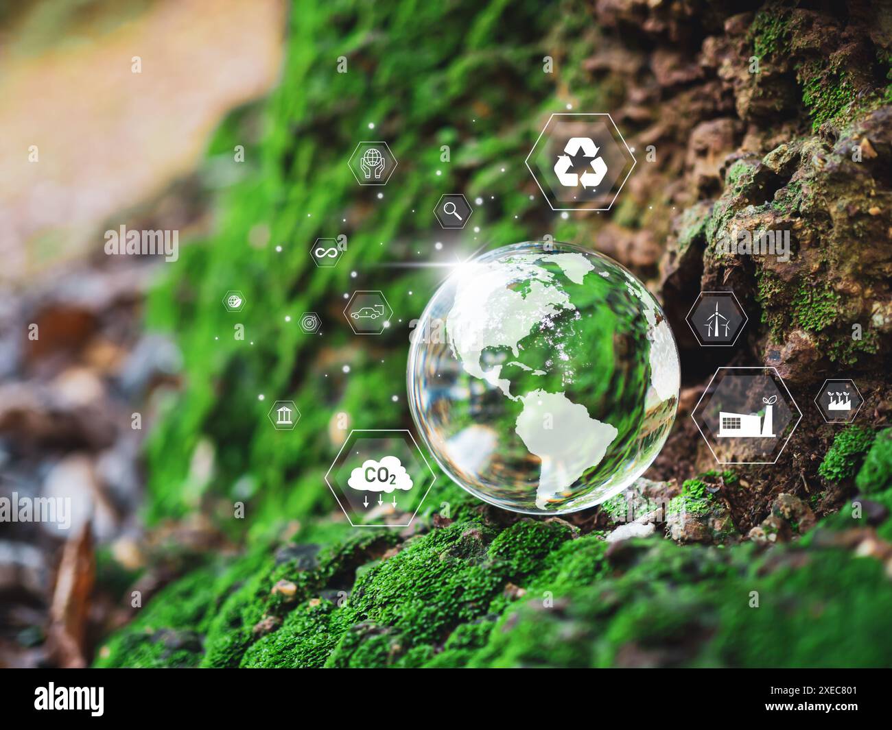 Una sfera di vetro con una mappa del mondo. Sfere adagiate su un pavimento di legno con varie icone e simboli. La scena è una di consapevolezza ambientale e di susta Foto Stock