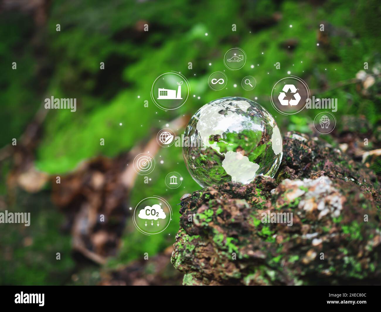 Una sfera di vetro con una mappa del mondo. Sfere adagiate su un pavimento di legno con varie icone e simboli. La scena è una di consapevolezza ambientale e di susta Foto Stock