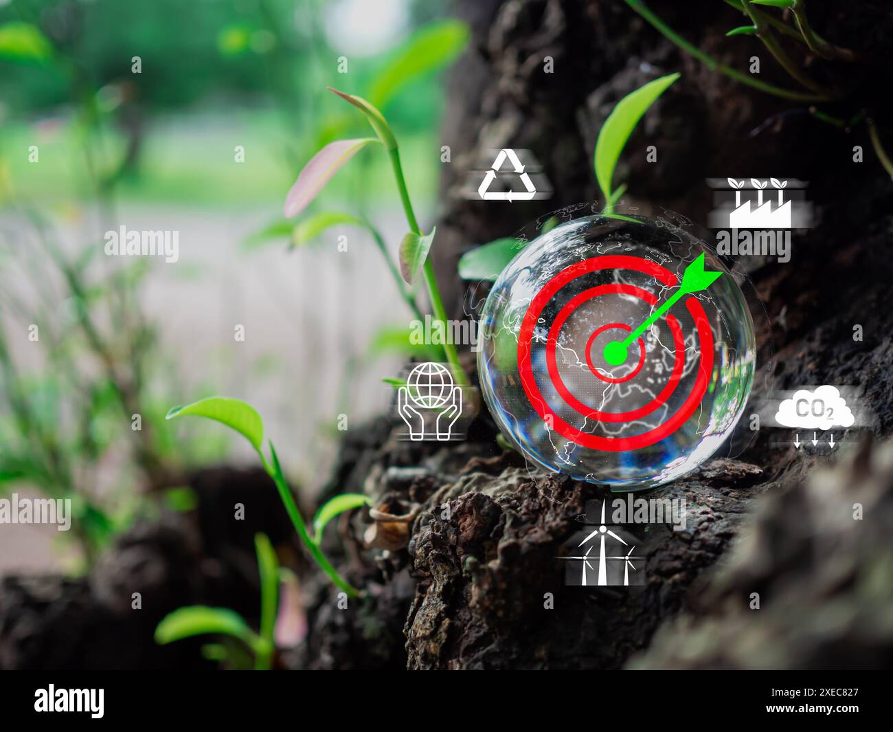 Una sfera di vetro con un bordo di freccette. Sfere adagiate su un pavimento di legno con varie icone e simboli. La scena è una di consapevolezza ambientale e conc Foto Stock