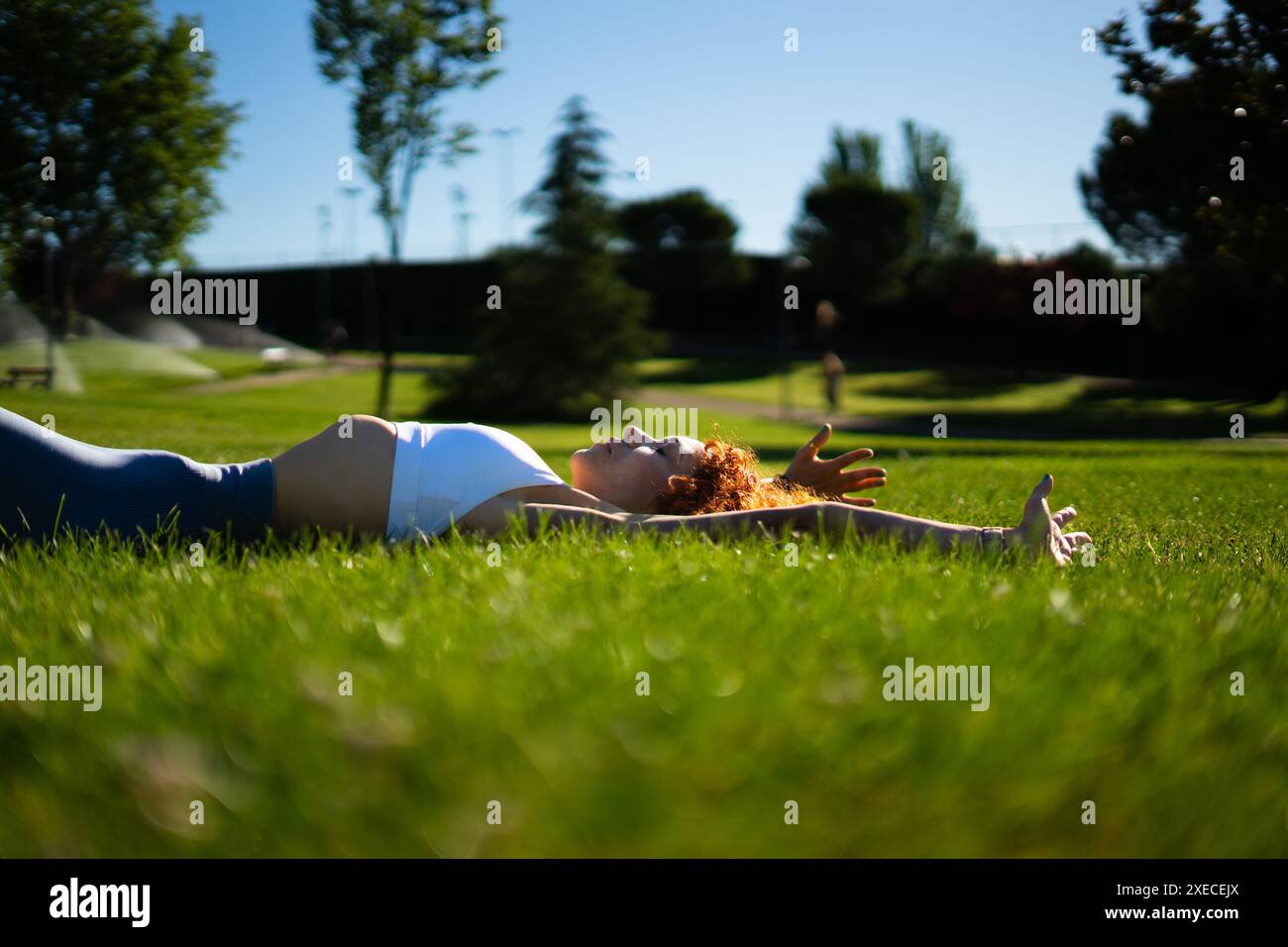 Donna che esercita il pavimento pelvico con esercizi ipopressivi in un parco al mattino Foto Stock