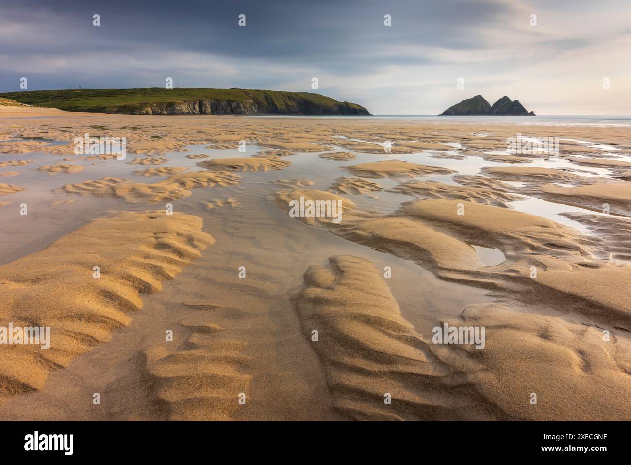 Piscine di marea nella distesa sabbiosa della spiaggia di Holywell Bay vicino a Newquay, Cornovaglia, Inghilterra. Estate (giugno) 2024. Foto Stock