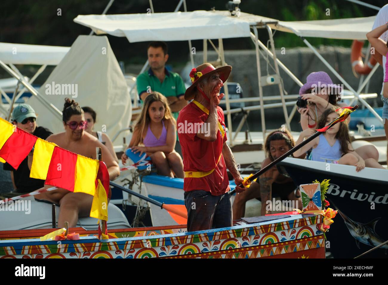 ACI TREZZA, ITALIA - 24 GIUGNO 2024 - Festa tradizionale di San Giovanni. Sfilata tradizionale di San Giovanni con pisci a mari dove riproducono la caccia al tonno. Il tonno viene derubato da un giovane che finalmente riesce a fuggire dai pescatori Foto Stock