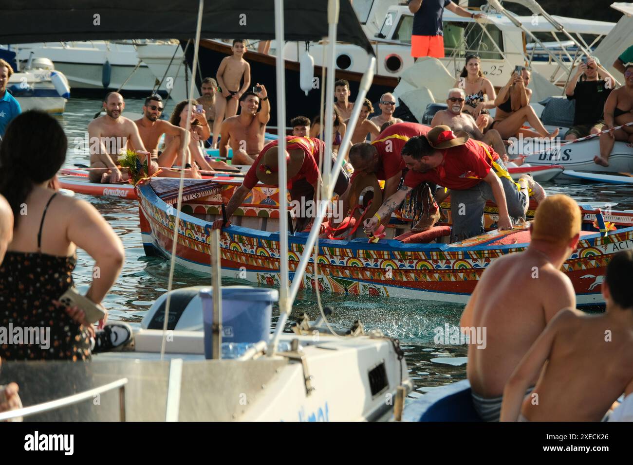 ACI TREZZA, ITALIA - 24 GIUGNO 2024 - Festa tradizionale di San Giovanni. Sfilata tradizionale di San Giovanni con pisci a mari dove riproducono la caccia al tonno. Il tonno viene derubato da un giovane che finalmente riesce a fuggire dai pescatori Foto Stock