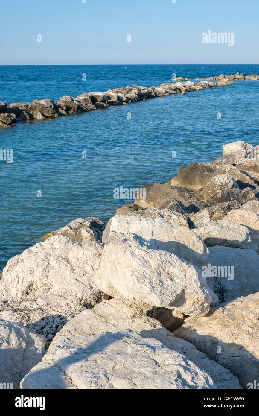 Grandi rocce che creano un piccolo porto sulla costa di pesaro in Italia. Foto Stock