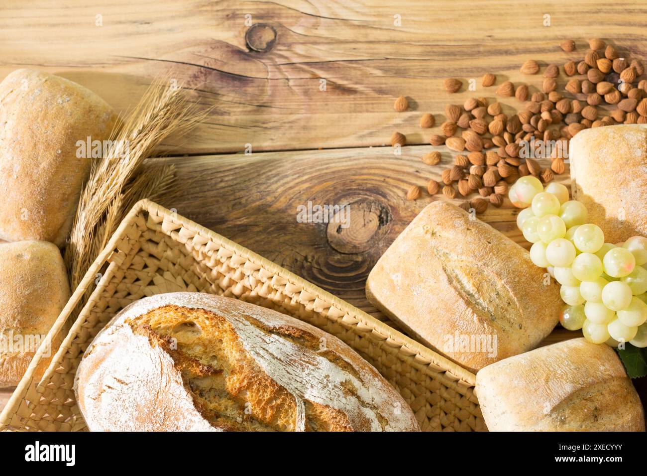 Fai shopping nella decorazione della panetteria con pane fresco, panini e orecchie di segale matura, e un mazzo luminoso di uva e semi di pesca amari. Foto Stock