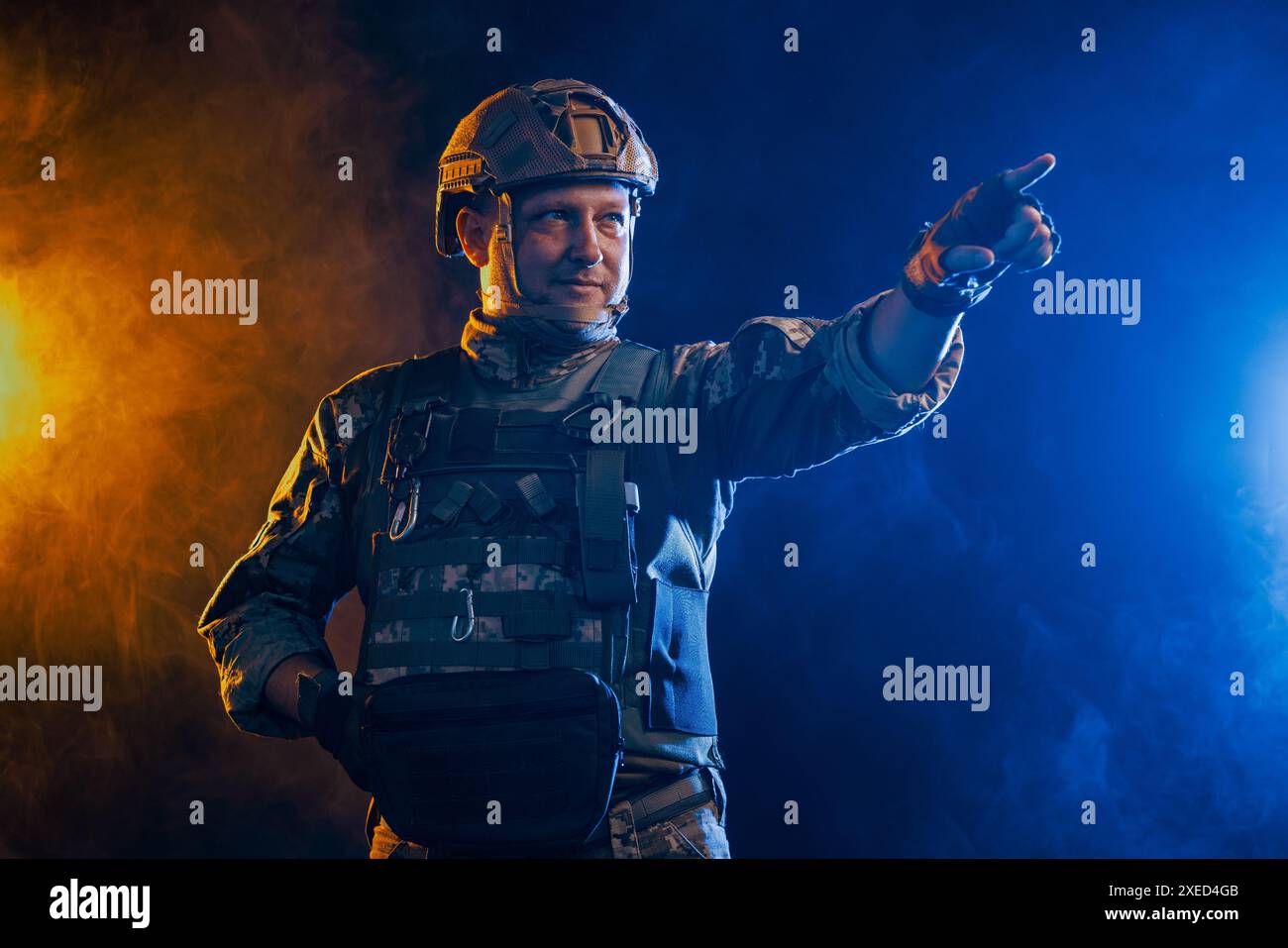 Un ritratto raffigura un soldato in equipaggiamento tattico sullo sfondo di intensi effetti fumo arancione e blu Foto Stock