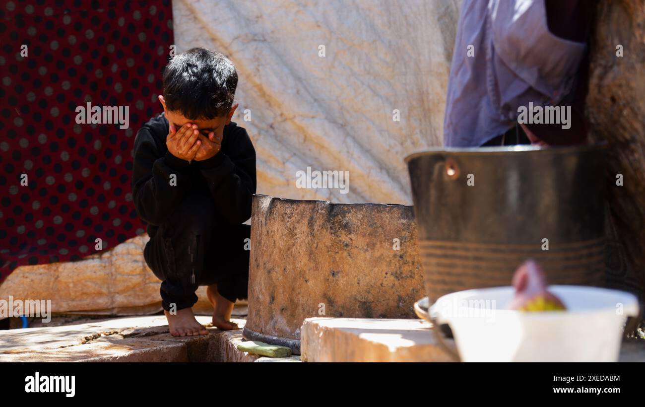 11 giugno 2024, Sarmada, Governatorato di Idlib, Siria: Sarmada, Idlib, Siria. 11 giugno 2024. Un bambino siriano sfollato fuori da una tenda nel campo di Tell al-Fakhar nel nord-ovest della Siria. Tell al-Fakhar è uno dei campi di sfollati interni (IDP) vicino a Sarmada, nel governatorato di Idlib. I residenti del campo di Tell al-Fakhar vivono in tende usurate per 6 anni dopo essere stati sfollati dalle loro case a seguito di scioperi effettuati dalle forze governative siriane (immagine di credito: © Hussein Ali/IMAGESLIVE via ZUMA Press Wire) SOLO PER USO EDITORIALE! Non per USO commerciale! Foto Stock