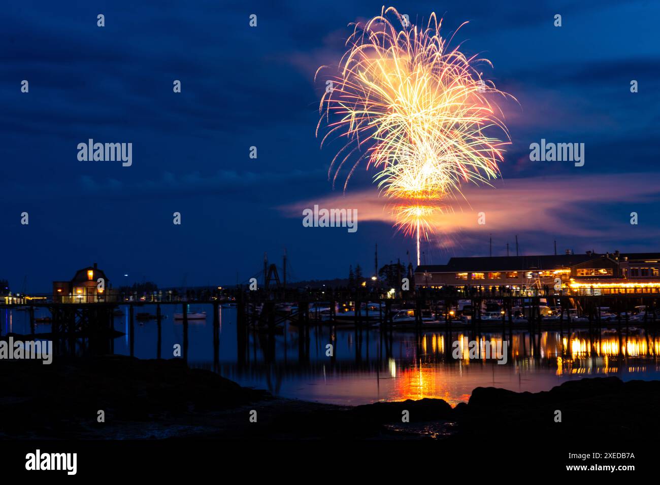 Boothbay Harbor, Stati Uniti. 26 giugno 2024. I fuochi d'artificio esplodono nel cielo sopra il porto e lo storico lungomare durante l'annuale festival Windjammer Days, 26 giugno 2024, a Boothbay Harbor, Maine. Windjammer Days, iniziato nel 1962, inizia la stagione estiva nella regione costiera. Crediti: Richard Ellis/Richard Ellis/Alamy Live News Foto Stock