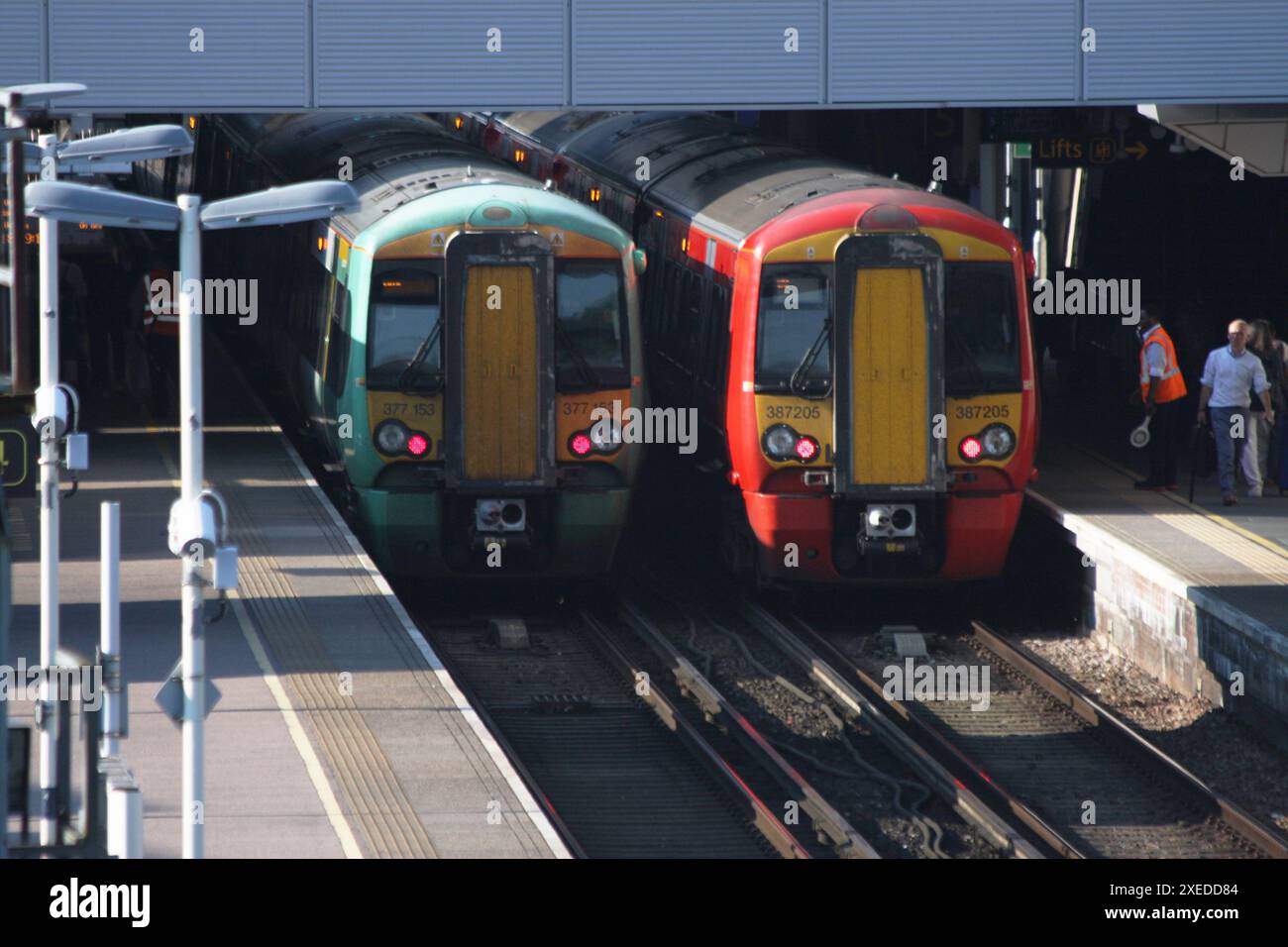 Un treno Southern Rail e un treno Gatwick Express fianco a fianco alla stazione di Gatwick Foto Stock