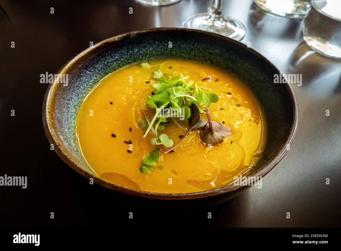 Microgreens su zuppa di zucca in un ristorante vegano, elegante piatto sano Foto Stock