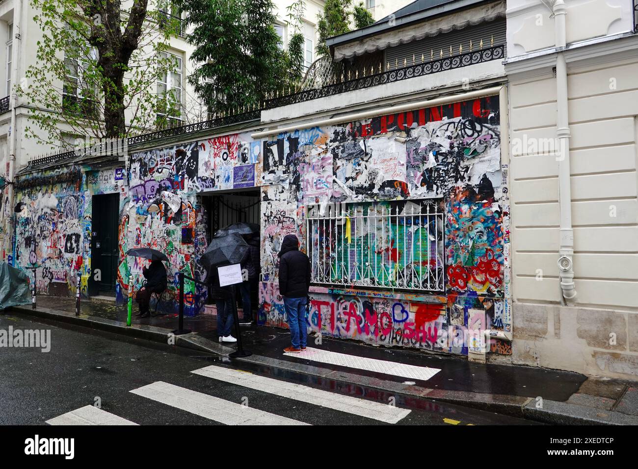 Persone che aspettano, sotto la pioggia, fuori dalla casa Serge Gainsbourg, Maison historique de Serge Gainsbourg, ora trasformata in museo, Parigi, Francia. Foto Stock