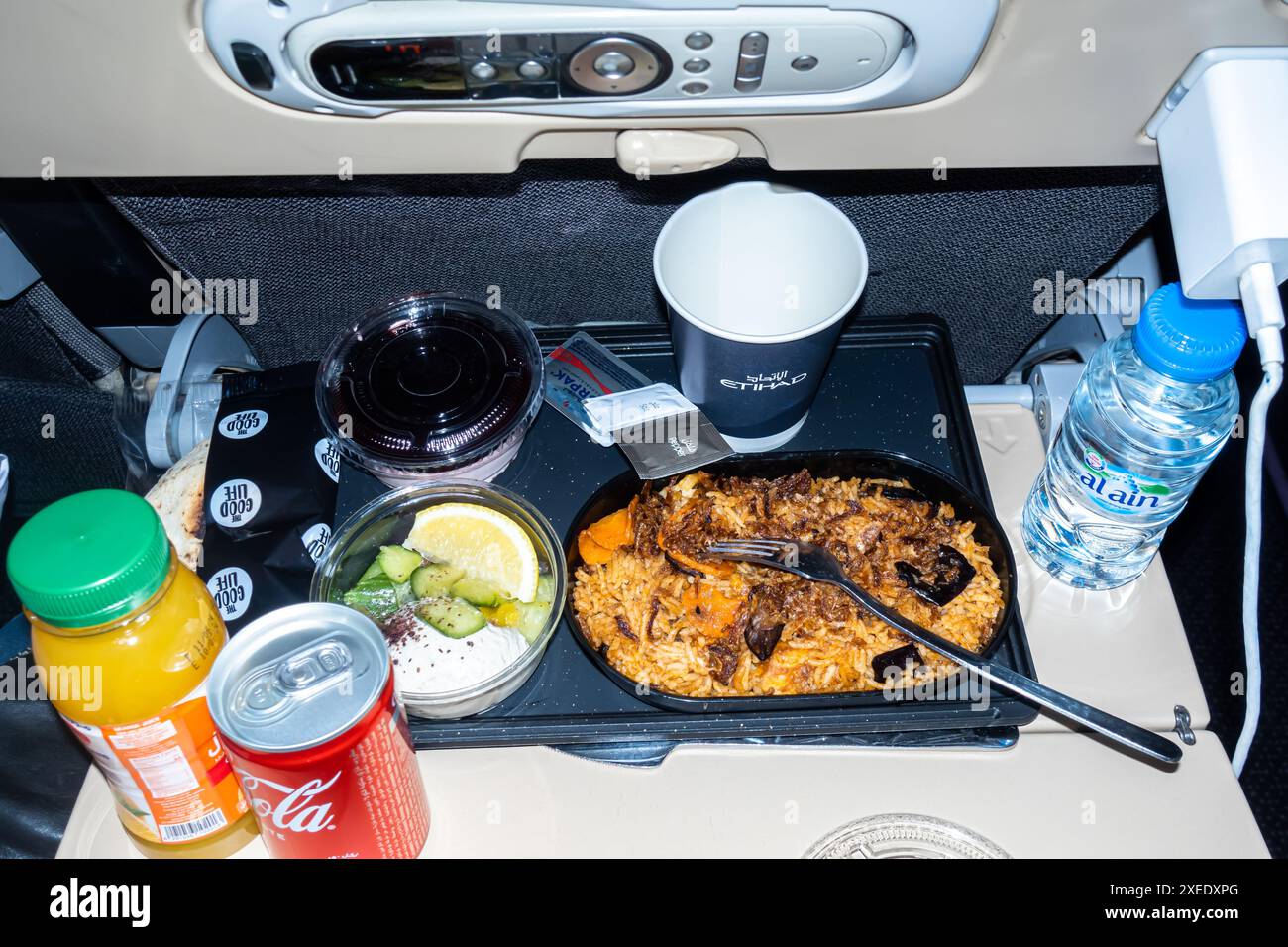 Cibo per aeroplani. Pranzo servito al posto dell'aereo in volo, pollo con riso, bevande, servito al posto dell'aereo nel volo Boeing 787-10 Etihad Airways Foto Stock