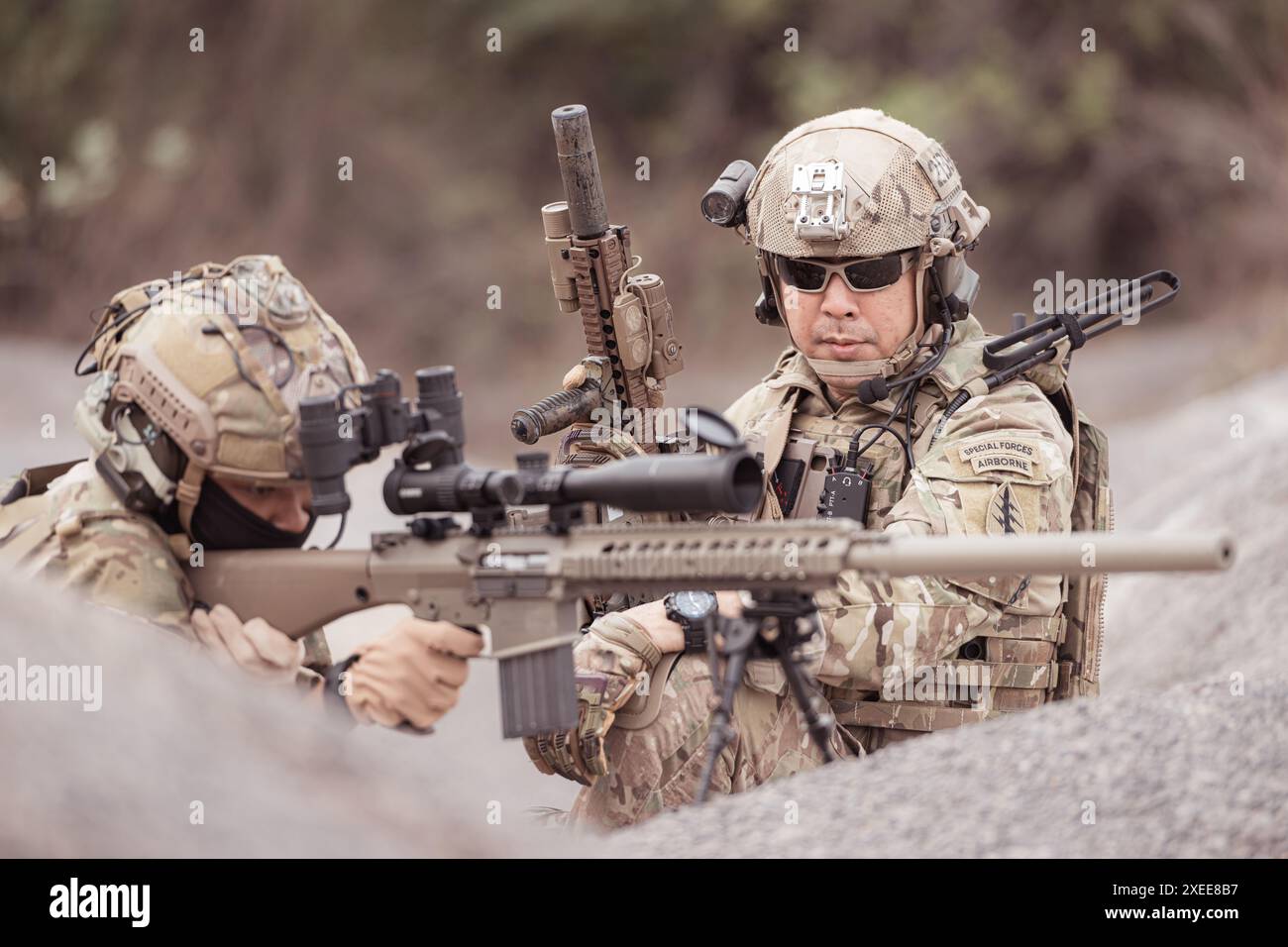 Soldati in uniformi militari mimetiche che trasportano armi, missioni di ricognizione in aspre montagne, battaglia di fanteria d'assalto Foto Stock