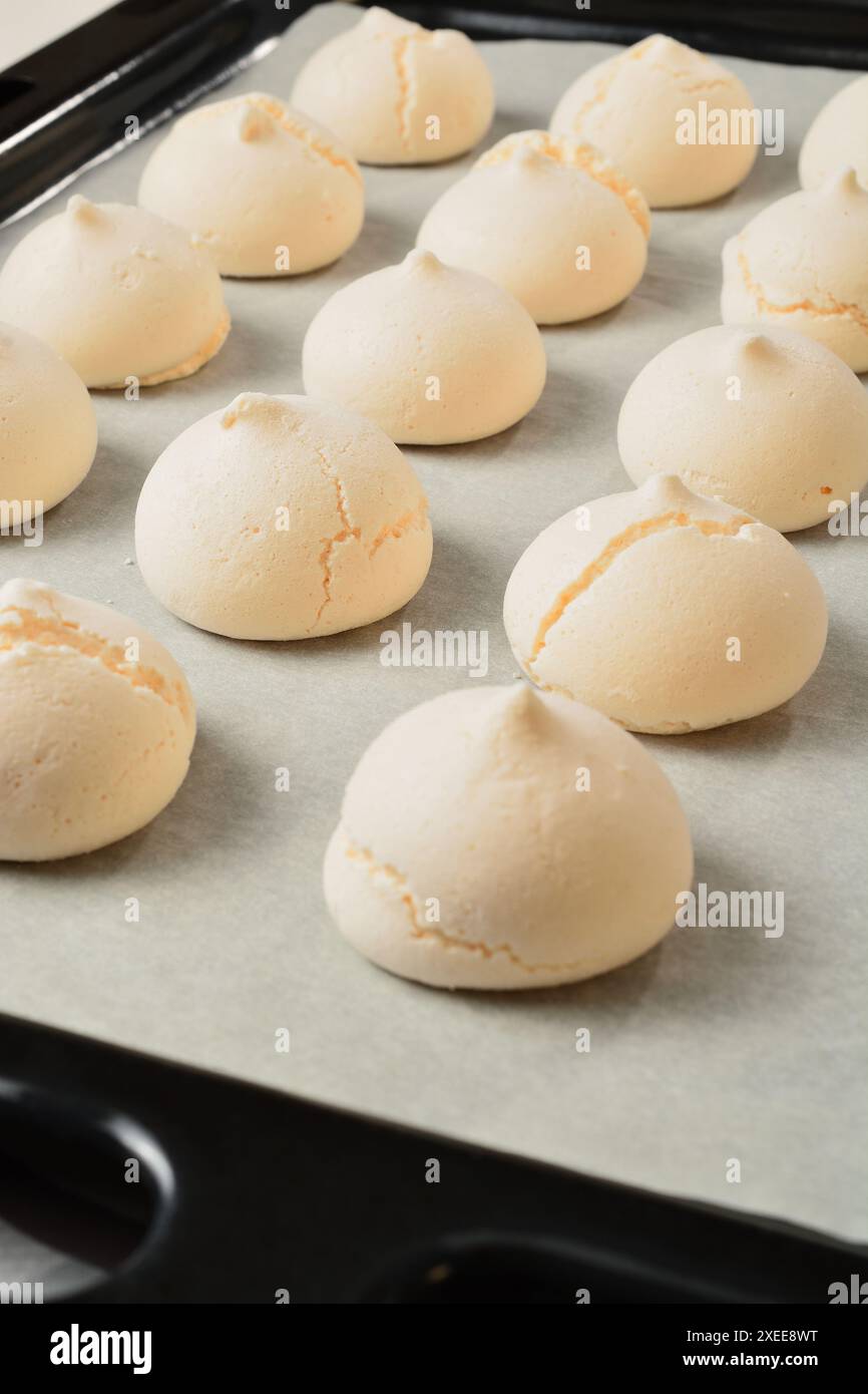 Meringhe dolci bianche su una teglia da forno. Foto Stock