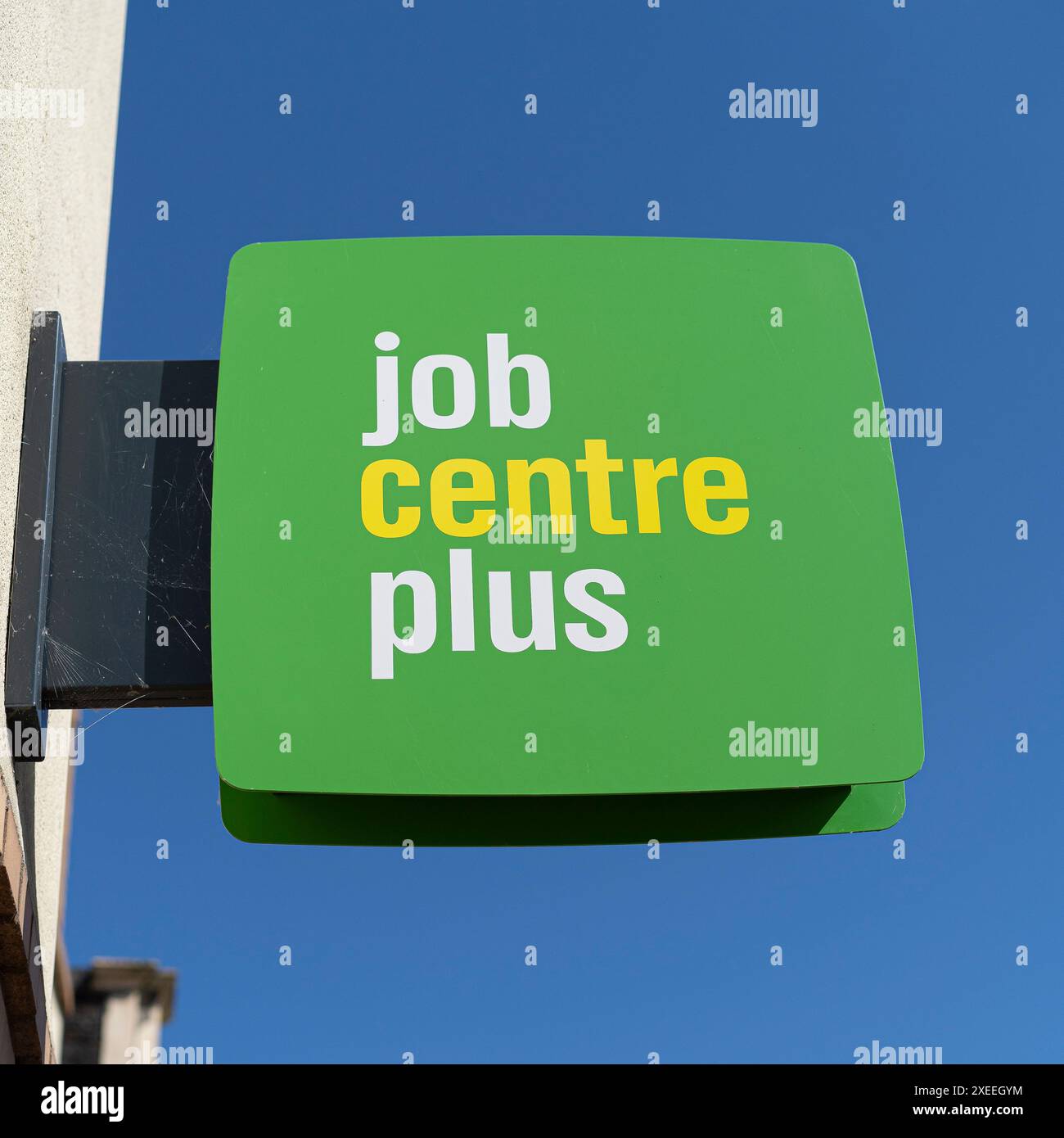 Vista ravvicinata di un cartello verde Job Centre Plus isolato all'esterno dell'edificio del Regno Unito con sfondo blu. Opportunità di lavoro, Gran Bretagna. Foto Stock