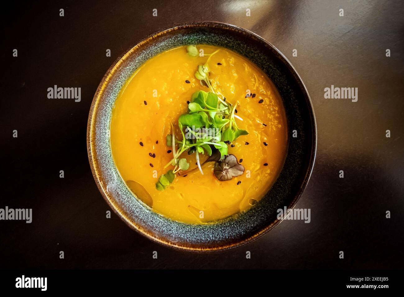 Microgreens su zuppa di zucca in un ristorante vegano, elegante piatto sano Foto Stock