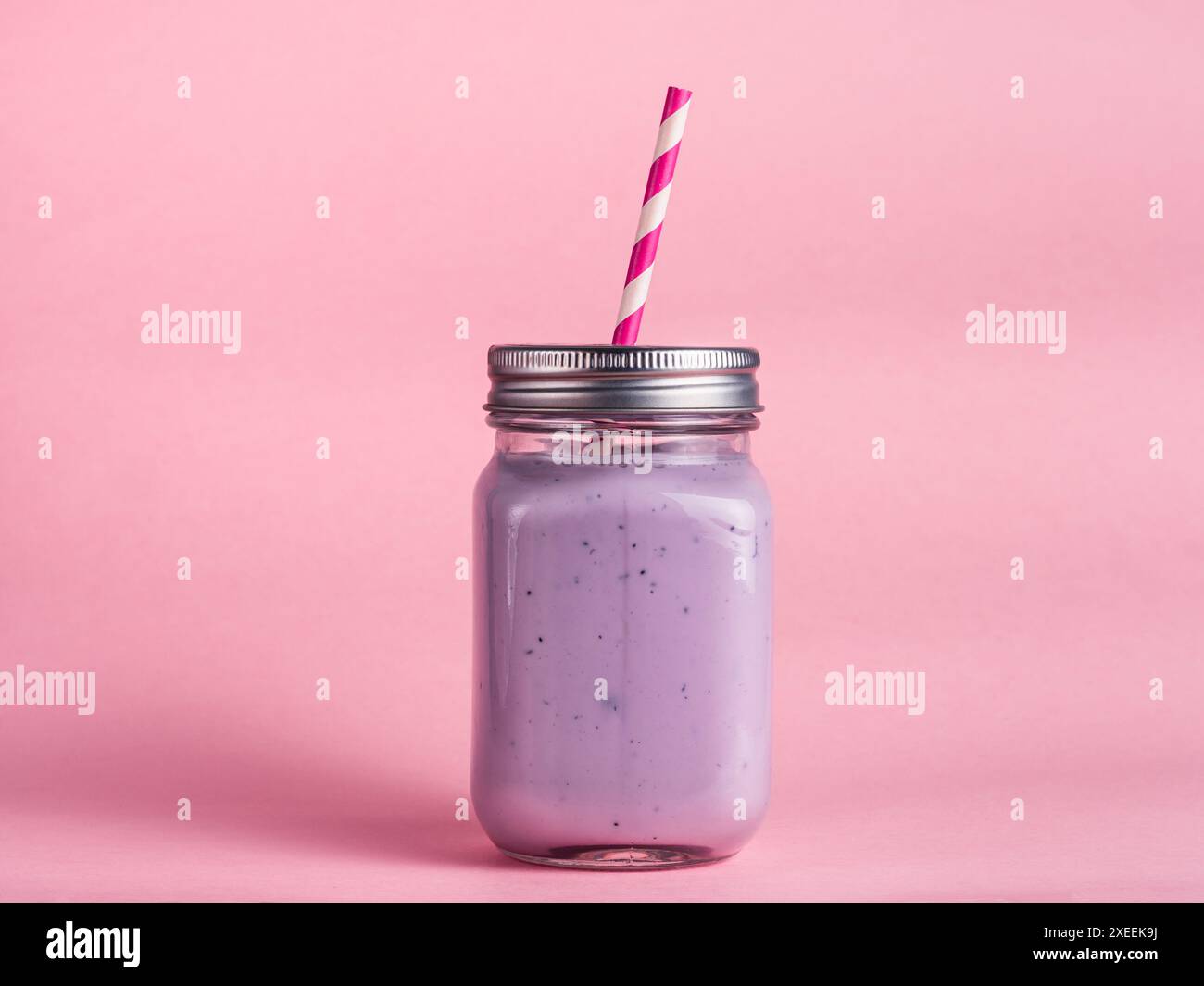 Frullato di mirtillo in vetro di vaso di mason su rosa Foto Stock