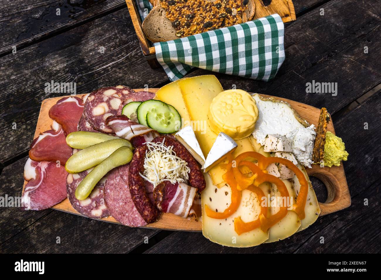 Un vassoio di snack della Filzmoosalm nella valle di Großarl, Salisburgo, Austria, visto dall'alto, presenta formaggio acido, Camembert, burro, formaggio a pasta dura, pancetta, prosciutto e salsiccia con pane fresco – tutto di produzione propria dell'alm. Foto Stock