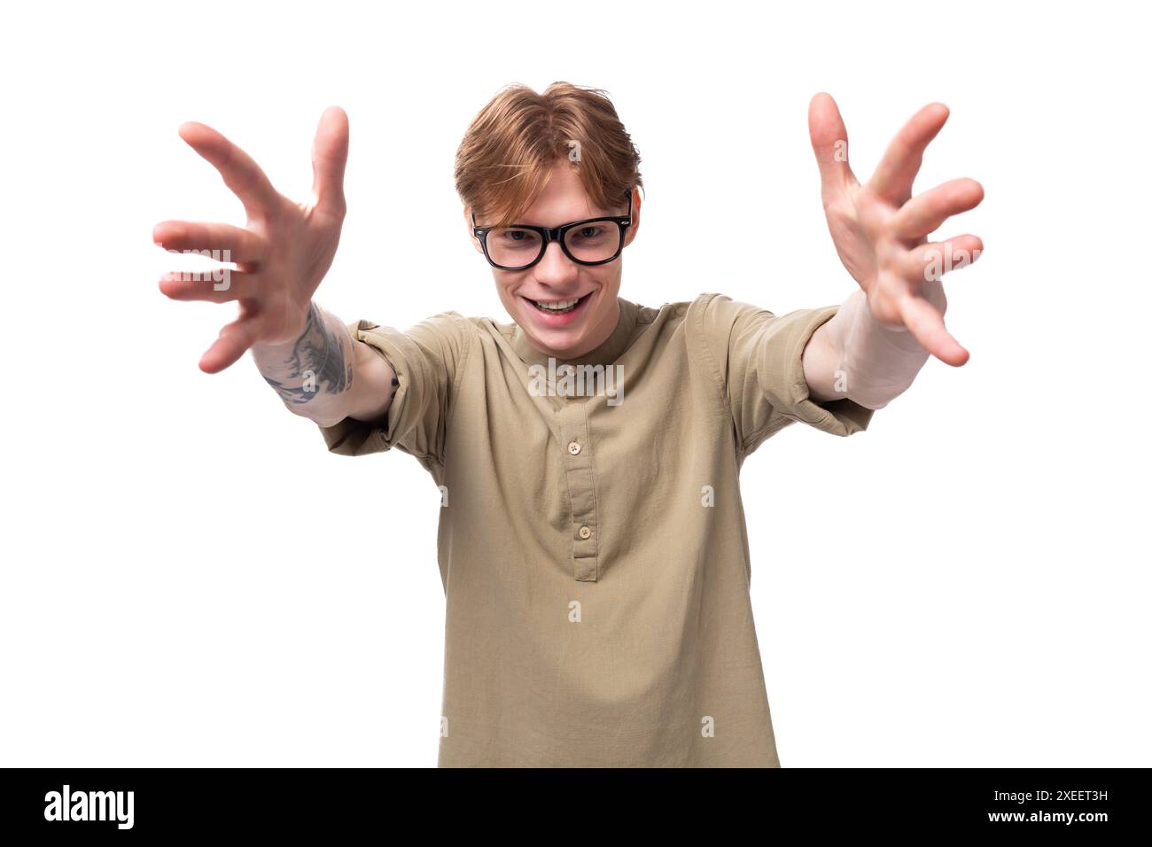 Giovane uomo europeo dai capelli rossi vestito con una camicia marrone chiaro con un tatuaggio Foto Stock