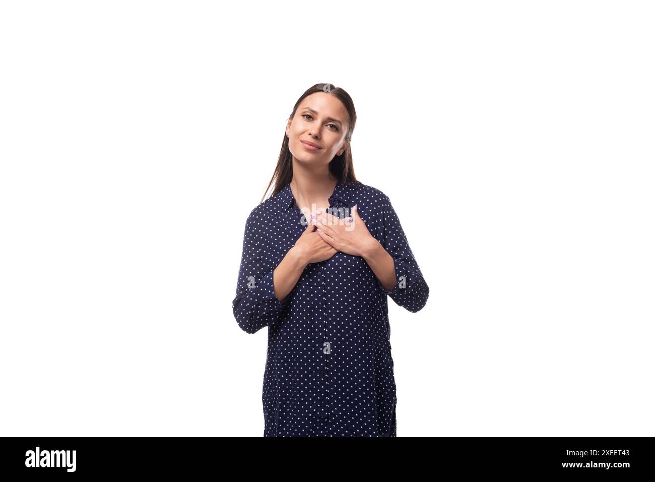 Giovane donna bruna caucasica alla moda vestita con una blusa blu scuro su sfondo bianco con spazio per le copie Foto Stock