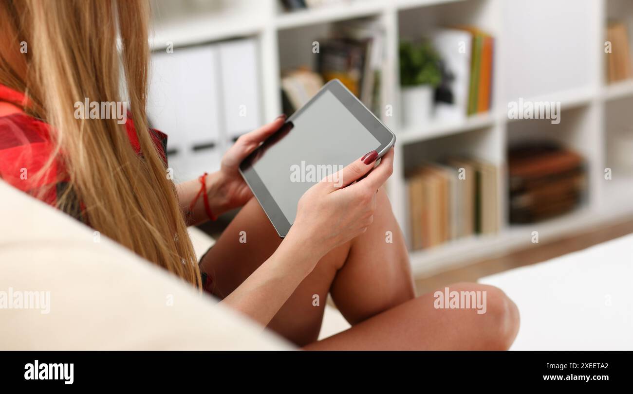 La donna di casa si sveglia la mattina e controlli news su reti sociali utilizzando tablet guardare divertenti video corrispondono con amici e seleziona doni holi Foto Stock