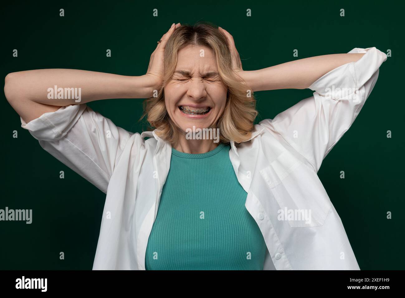 Donna che tiene le mani sulla testa Foto Stock