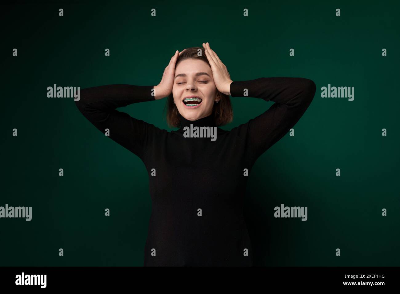 Donna con le mani sulla testa Foto Stock