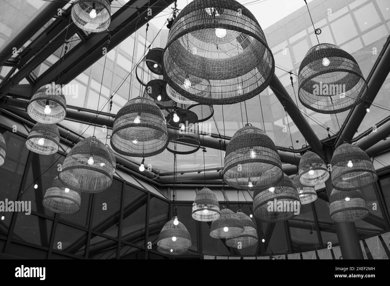 Lampade con sfumature in vimini sotto un soffitto di vetro nel moderno business center o ristorante. Foto Stock Lampade con sfumature in vimini sotto un soffitto di vetro nel moderno business center o ristorante. Foto Stock