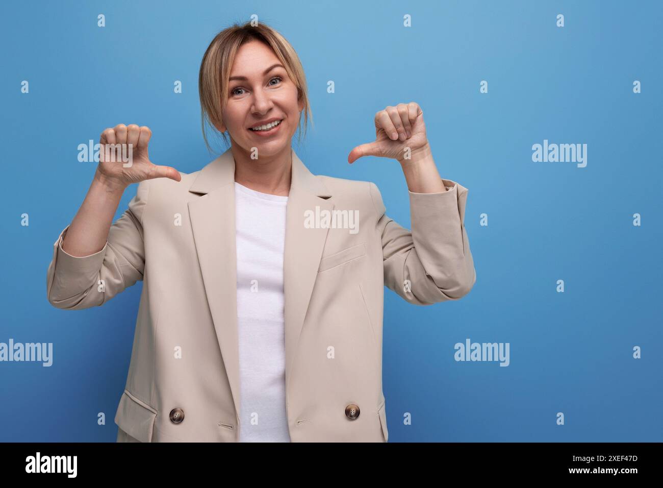 Ritratto di una giovane donna d'affari bionda gentile e piacevole in una giacca sullo sfondo con spazio per le copie Foto Stock