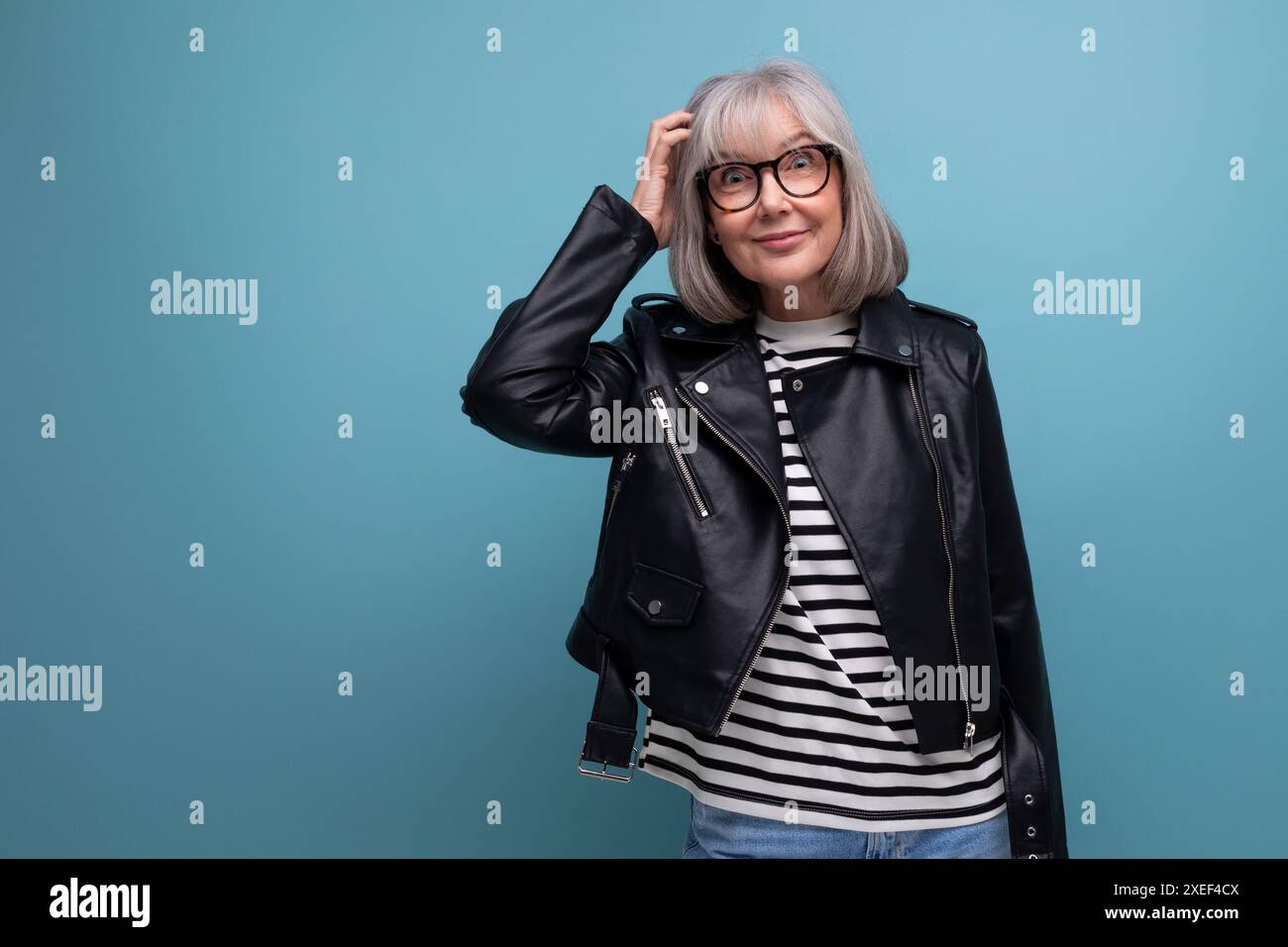Donna di mezza età dai capelli grigi, fresca e informale, nonna in giacca rocker su sfondo luminoso con spazio per le copie Foto Stock