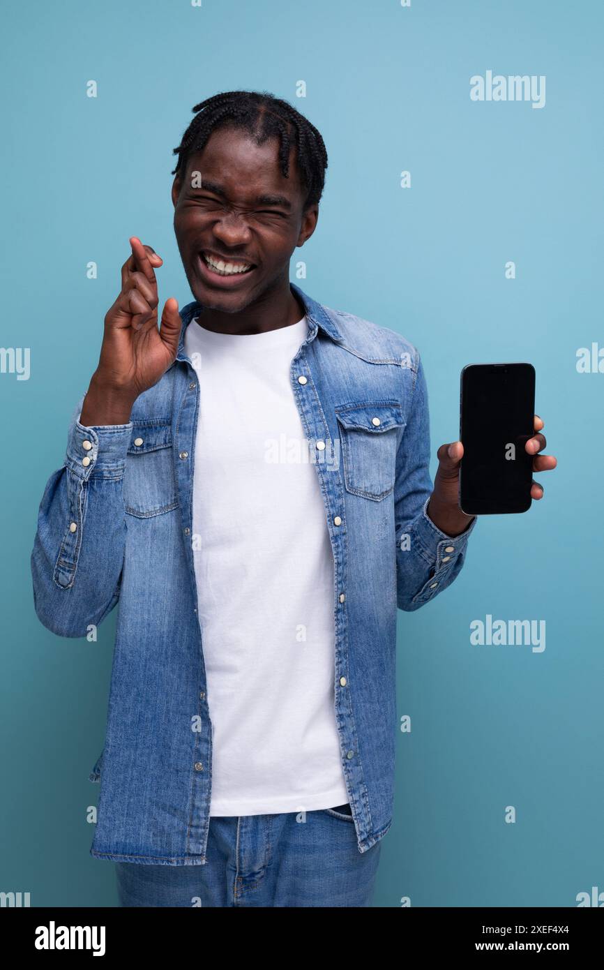 Uomo africano sorridente con dreadlock neri che usano lo smartphone Foto Stock