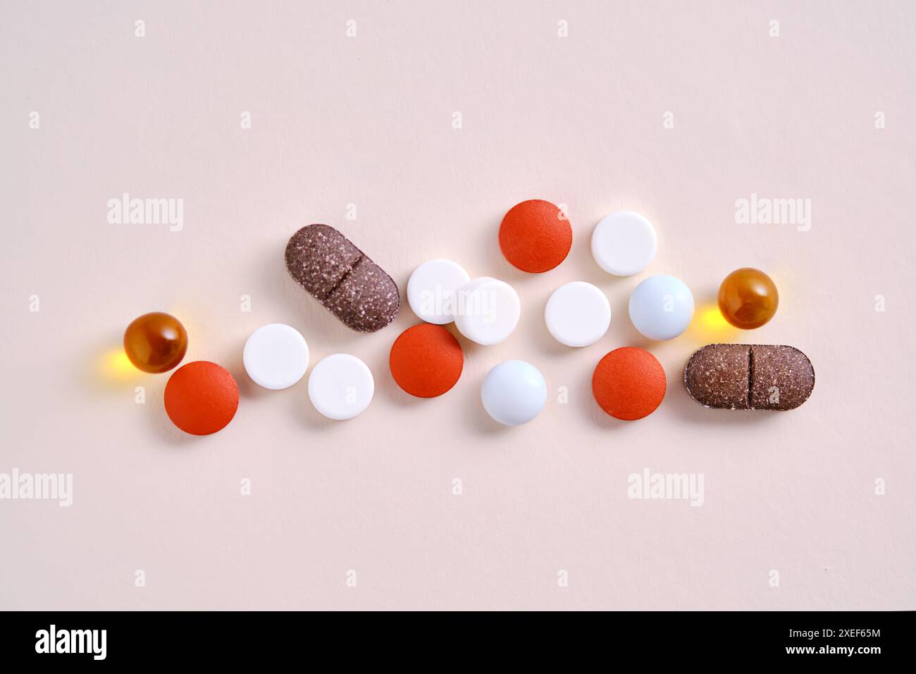 Pillole, vitamine e integratori alimentari su sfondo beige. Foto Stock