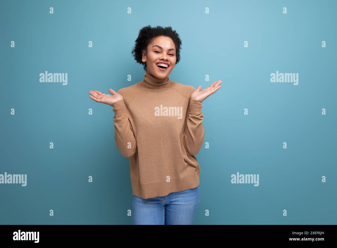 Giovane e attraente donna latina con capelli afro neri tirata indietro in coda di cavallo isolata sullo sfondo con spazio di copia Foto Stock