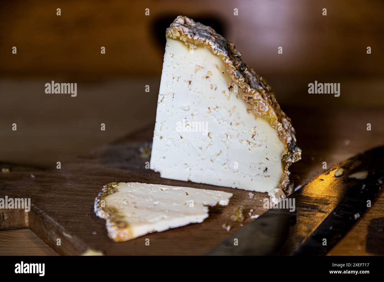 Il formaggio acido è una specialità della valle di Grossarl. Questa fetta proviene dalla Filzmoosalm vicino a Großarl, Salisburgo, Austria. Il formaggio grigio è prodotto con latte scremato. Ogni rifugio alpino ha la sua ricetta familiare per il suo ‚Sauakas‘. I caseari alpini lo chiamano anche ‚formaggio dello sportivo‘ per il suo alto contenuto di proteine e basso contenuto di grassi. Il formaggio acido di Bettina Huber di Grossarl della Filzmoosalm è stato nominato ‚Almenweg Schmankerl des Jahres‘ (prelibatezza dell’Almenweg dell’anno) nel 2022. Foto Stock